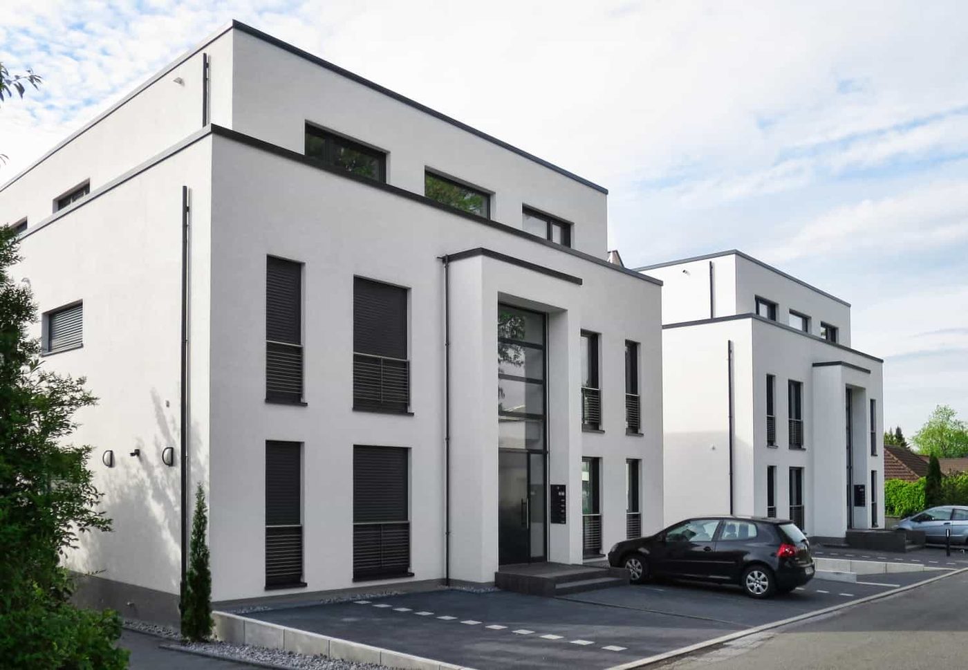 Stadtvilla in Dortmund-Kirchhörde mit weißer Putzfassade und dunklen Fensterrahmen